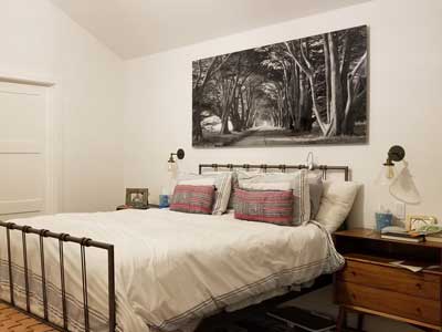 A black and white nature photo hanging above a bed.